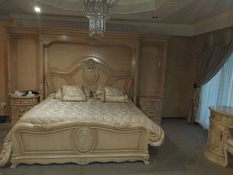 Spacious bedroom featuring a coffered ceiling with recessed lighting and extensive built-in cabinetry surrounding the bed area.