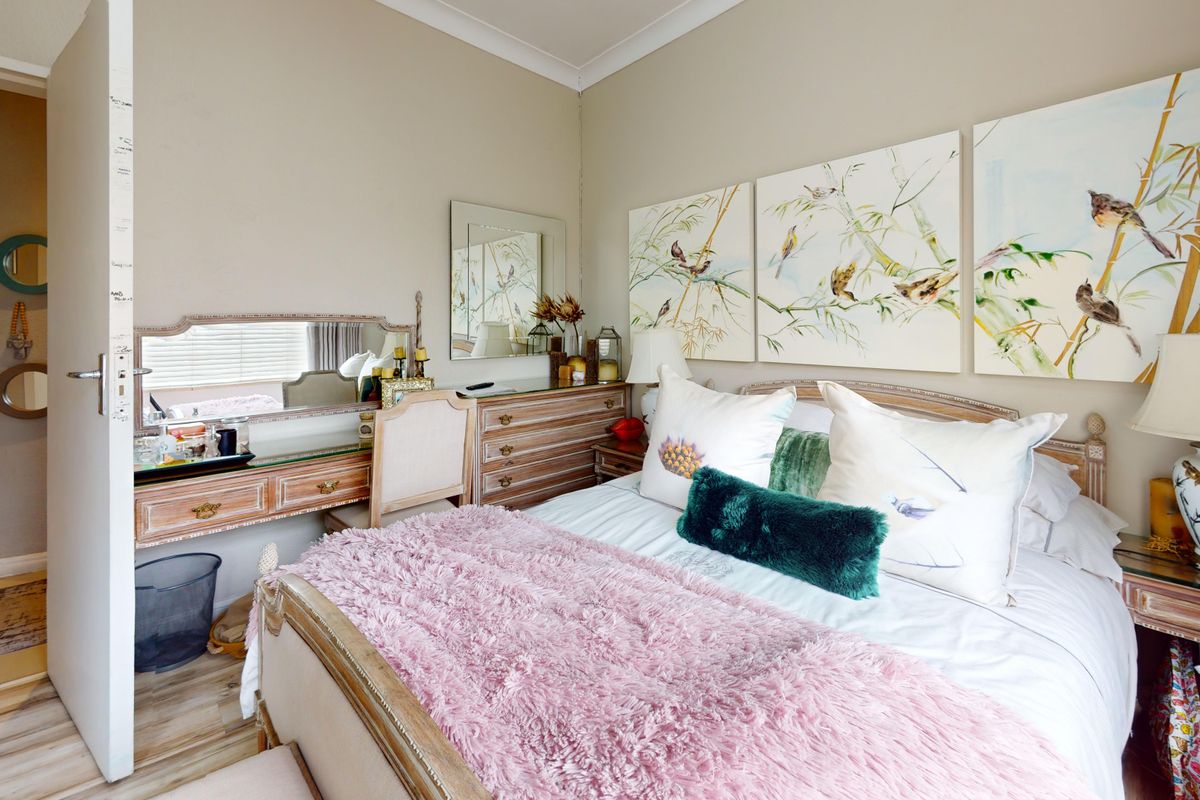 A well-maintained bedroom featuring neutral wall tones, coving, and laminate flooring, providing a comfortable and functional living space.