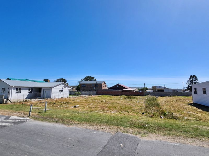 A vacant residential plot of land situated in a developed neighborhood, featuring level ground and street access.