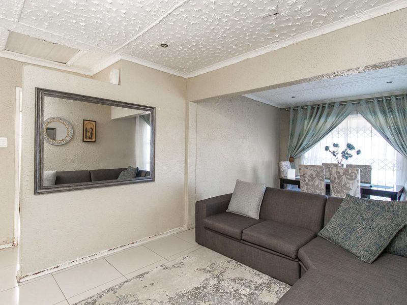 Open plan living and dining area featuring tiled floors and textured ceilings, offering a versatile space for family living and entertaining.