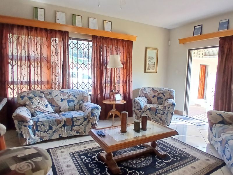 A living room featuring tiled flooring, wooden pelmets, and a sliding door providing access to the exterior.