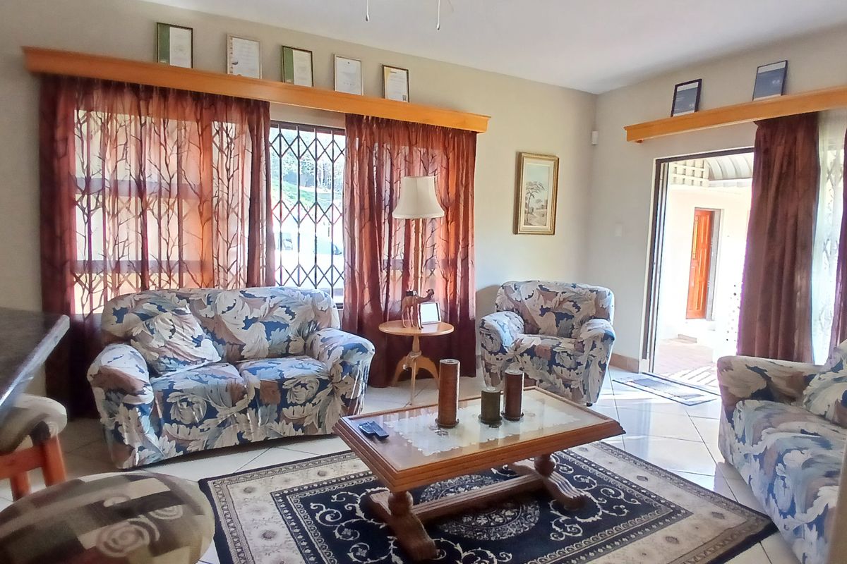 A living room featuring tiled flooring, wooden pelmets, and a sliding door providing access to the exterior.