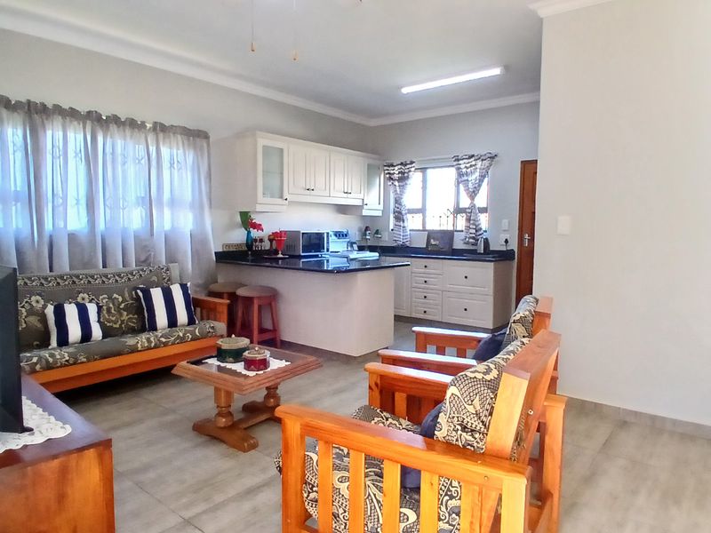 Open plan living area featuring a functional kitchen with granite countertops and tiled flooring throughout.
