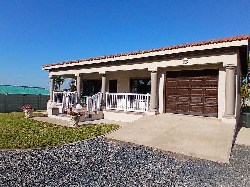 Front view of a single-story house featuring a covered patio, decorative columns, a single garage, and a concrete driveway.