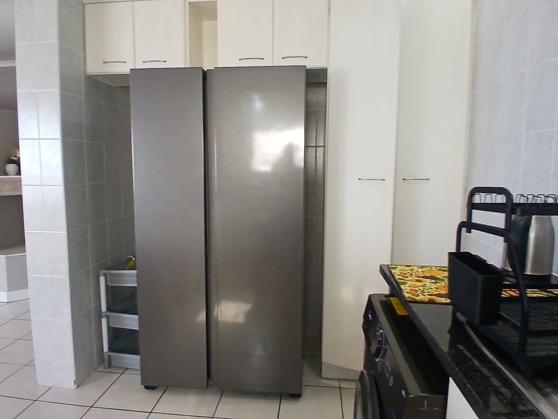 A functional kitchen area featuring built-in cabinetry, tiled wall finishes, and granite countertops, providing a practical layout for daily use.