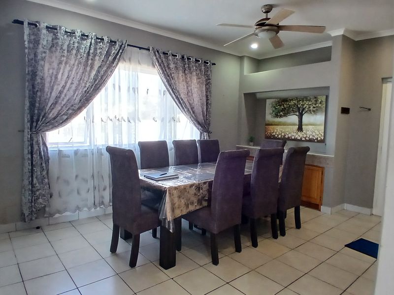 Dining room featuring tiled flooring, a ceiling fan, and a built-in display niche with cabinetry.