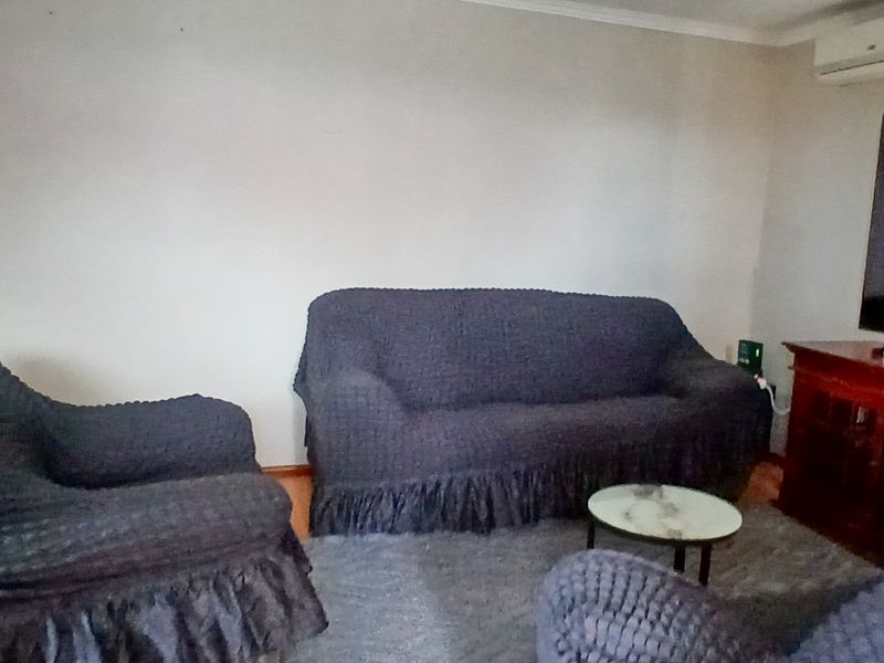 A living room featuring a wall-mounted split-system air conditioner and coving detail.