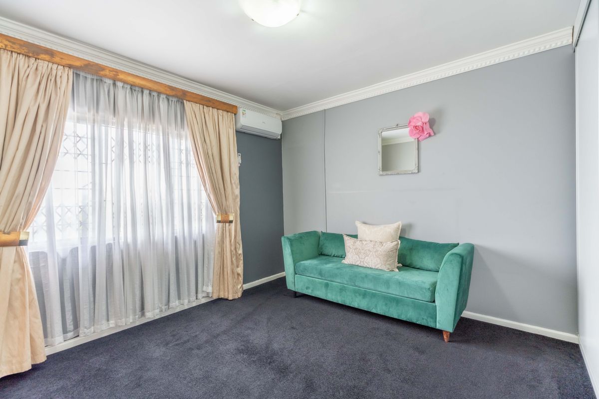 A bedroom featuring dark carpeting, crown molding, a split-system air conditioner, and a built-in wardrobe.