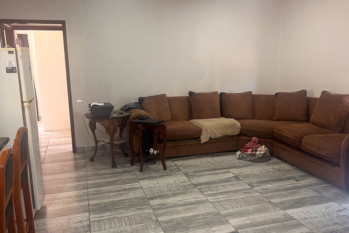 A living room area featuring tiled flooring and neutral wall finishes, providing a functional space for relaxation.