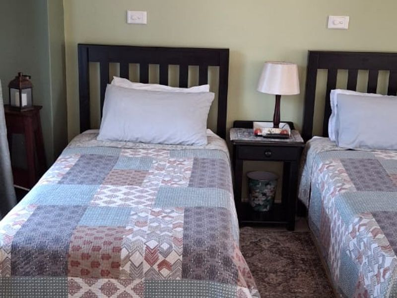 A bedroom featuring ceramic tiled flooring, wall-mounted sconce lighting, and coved ceiling cornices.