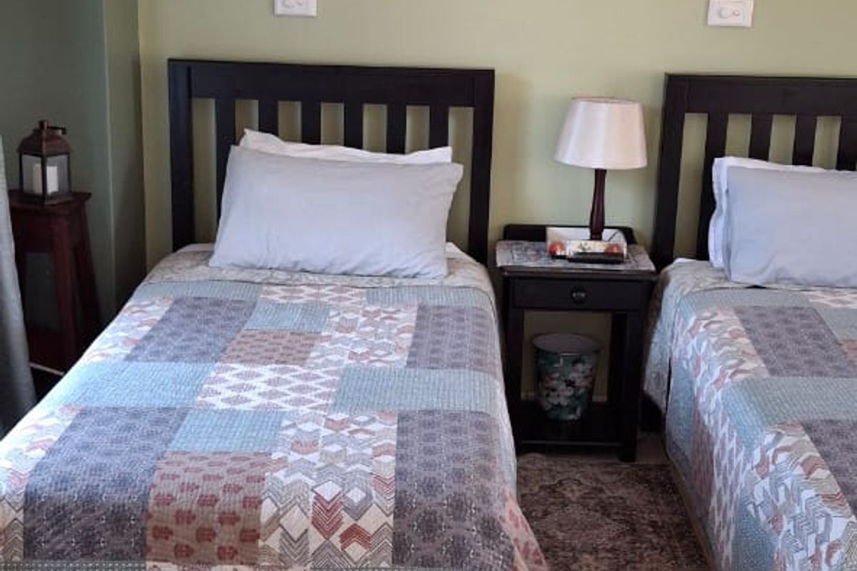 A bedroom featuring ceramic tiled flooring, wall-mounted sconce lighting, and coved ceiling cornices.