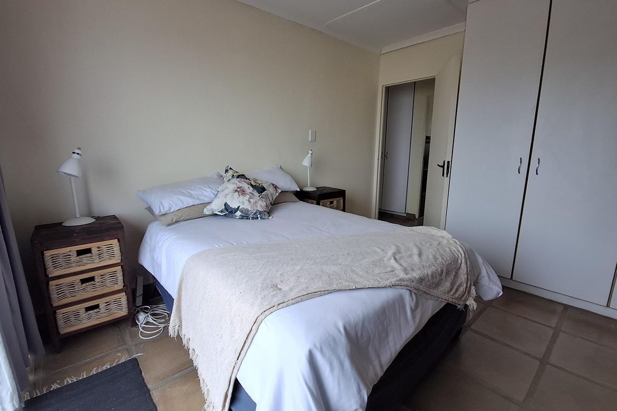 A functional bedroom featuring tiled flooring and a built-in wardrobe, offering a neutral canvas for potential updates.