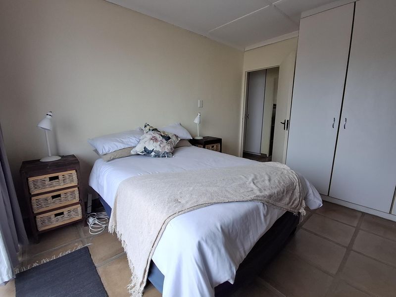 A functional bedroom featuring tiled flooring and a built-in wardrobe, offering a neutral canvas for potential updates.