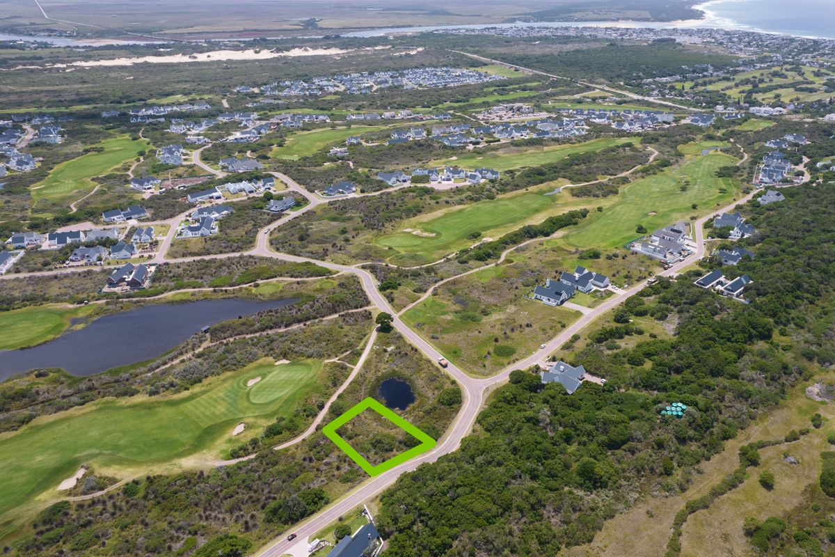 Aerial view of a vacant residential plot situated within a coastal golf estate, offering scenic surroundings and proximity to local amenities.