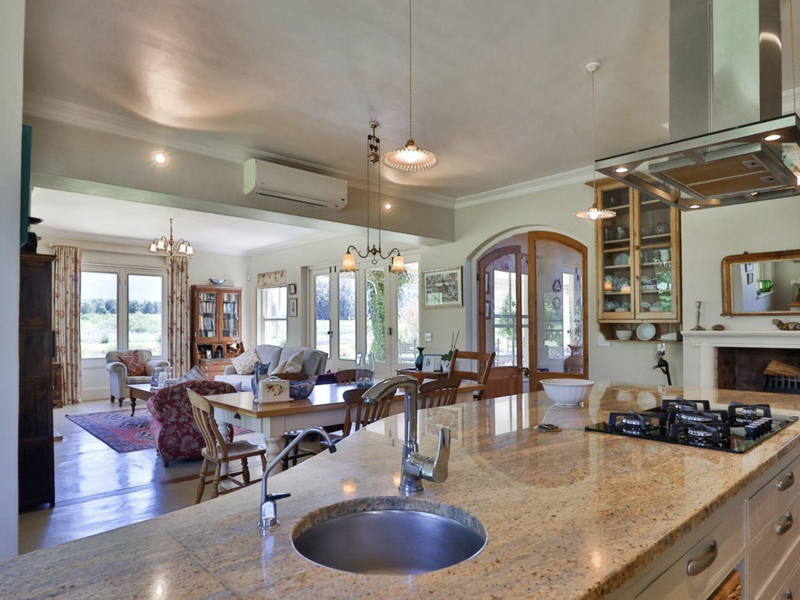 Spacious open-plan living area featuring a well-appointed kitchen with granite island, gas hob, and seamless flow to the dining and lounge spaces.
