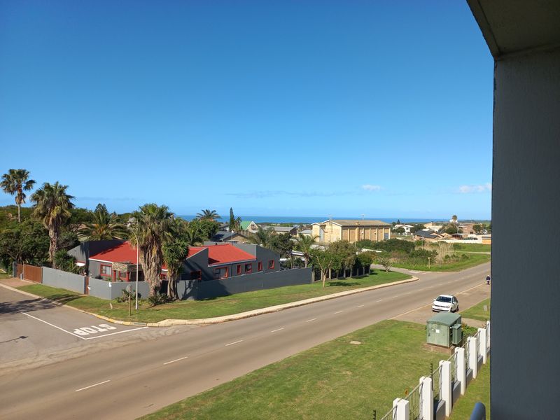 An elevated view overlooking the surrounding neighbourhood, street, and distant coastline.