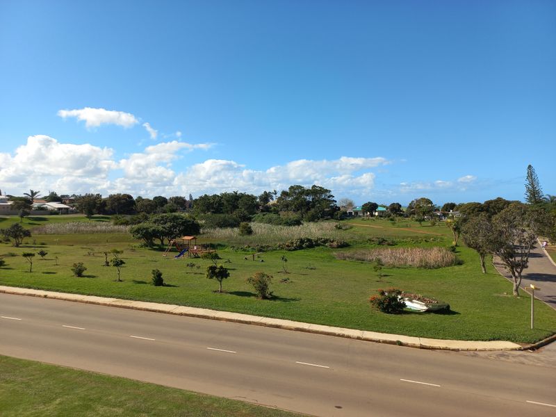 An elevated view overlooking a landscaped green space, park area, and local road infrastructure.