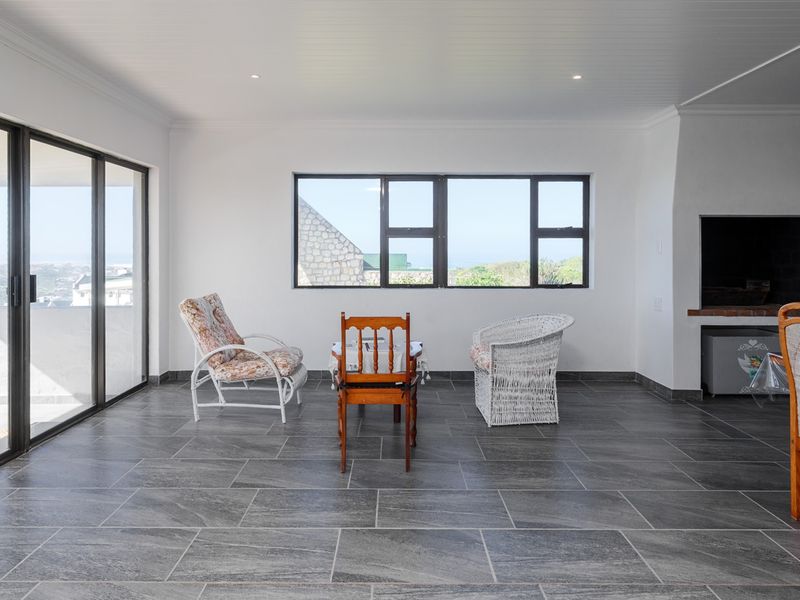 Spacious open-plan living area featuring modern tiled flooring, a built-in fireplace, and large sliding glass doors leading to an outdoor space.