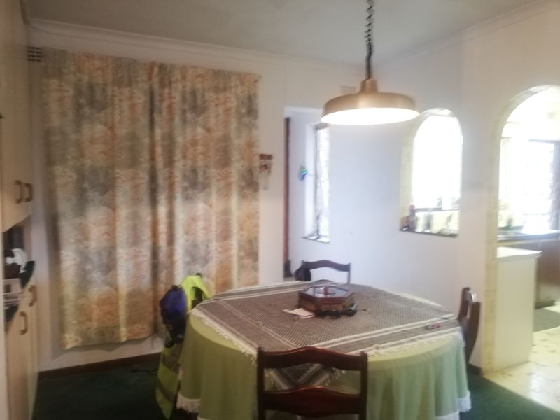 A dining area featuring an arched entryway, built-in cabinetry, and a central pendant light fixture.