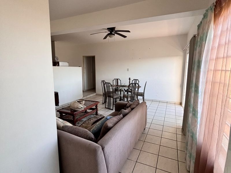 Open plan living and dining area featuring tiled flooring and a ceiling fan, providing a functional layout for daily living.