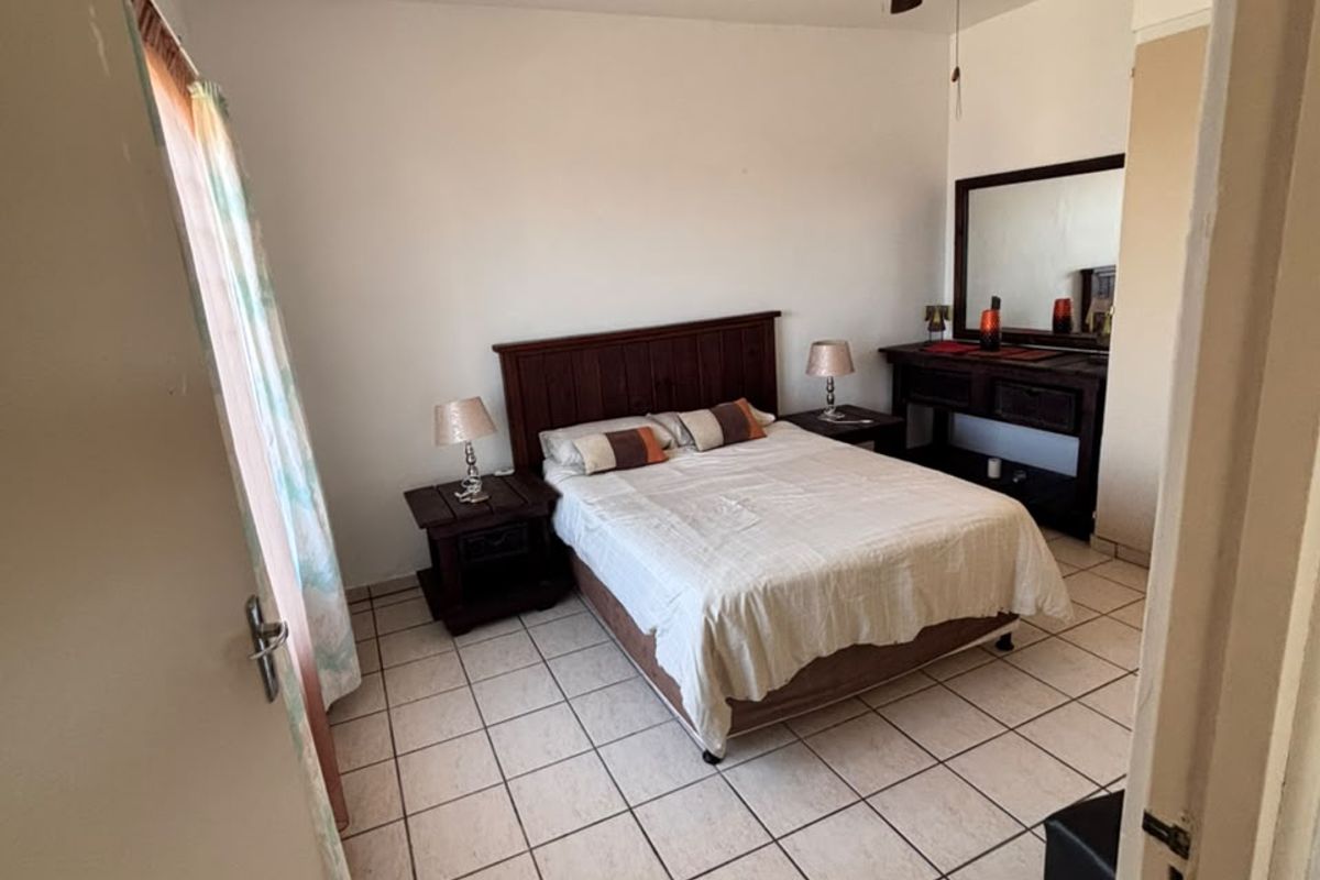 A bedroom featuring ceramic tile flooring and a ceiling fan, offering a functional space with neutral wall finishes.