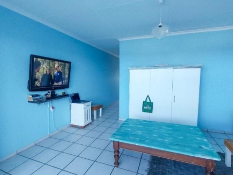 A living area featuring bright blue walls and tiled flooring, providing a blank canvas for potential interior design updates.
