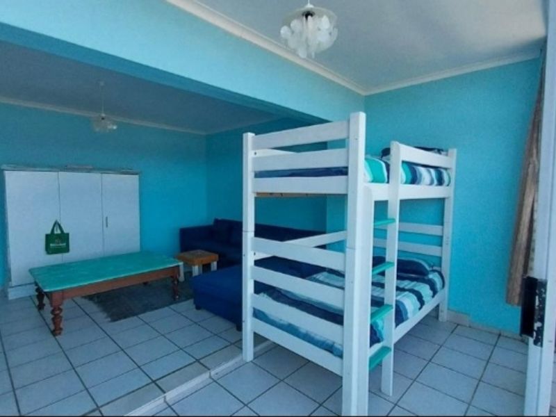 A bedroom space featuring tiled flooring and bright blue wall finishes, providing a functional area for sleeping and relaxation.