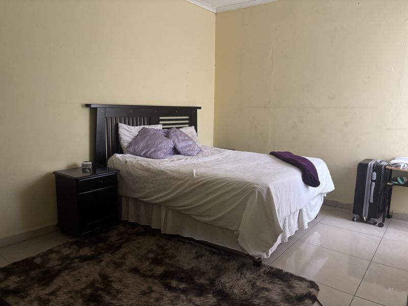 A bedroom featuring tiled flooring and neutral wall finishes, offering a functional space ready for cosmetic updates and personalization.