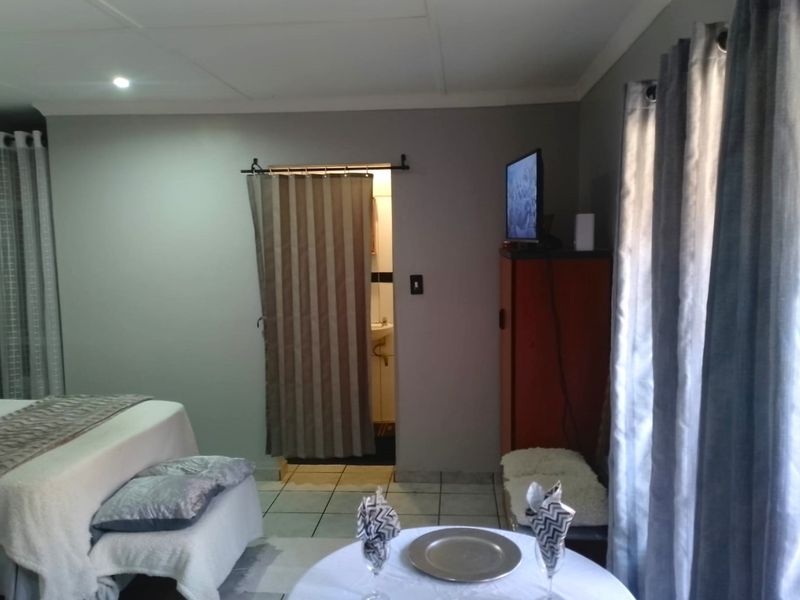 A bedroom featuring tiled flooring, recessed ceiling lighting, and direct access to an en-suite bathroom area.