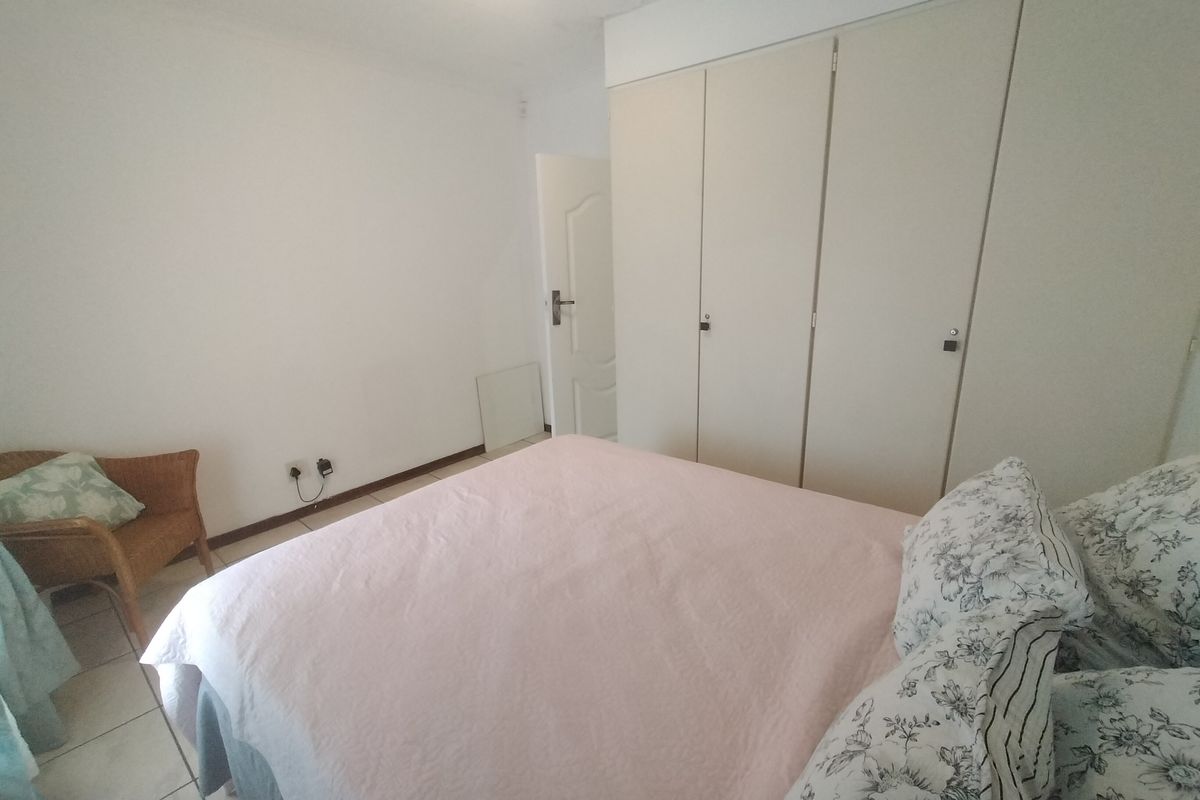 A functional bedroom featuring built-in cupboards and tiled flooring, offering a neutral base for personalization.