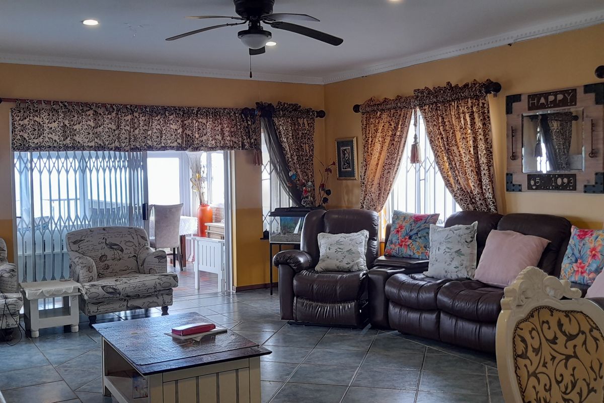 Spacious living room featuring tiled flooring, recessed lighting, a ceiling fan, and sliding glass doors leading to an outdoor area.