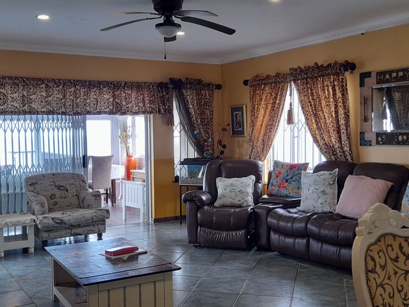Spacious living room featuring tiled flooring, recessed lighting, a ceiling fan, and sliding glass doors leading to an outdoor area.