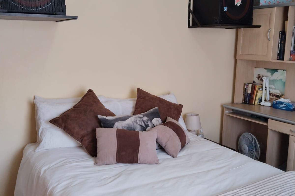 A bedroom featuring a built-in desk and shelving unit, providing functional storage and workspace within the room.