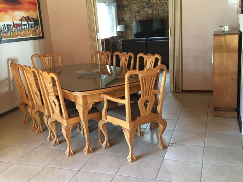 Dining room featuring tiled flooring and a timber ceiling, with a folding door leading to an adjacent living area with stone feature wall.
