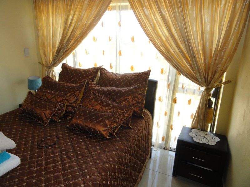 A bedroom featuring tiled flooring and a sliding glass door providing natural light.