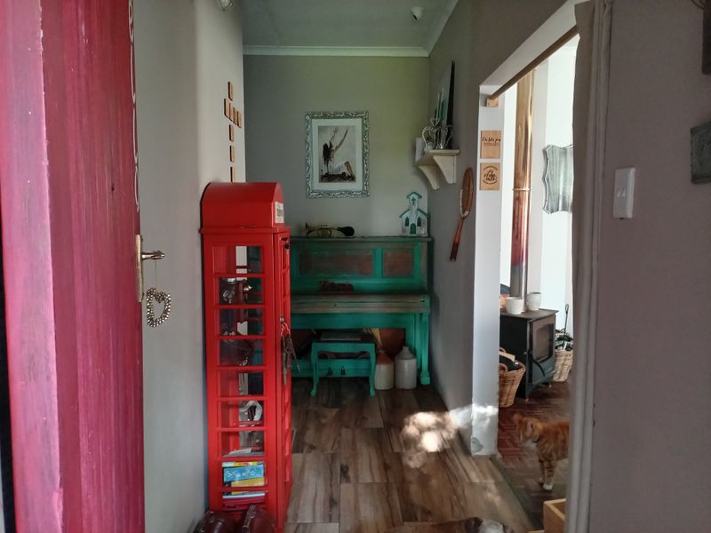 A hallway entrance area featuring wood-look tile flooring, leading into an adjacent living space equipped with a wood-burning stove.