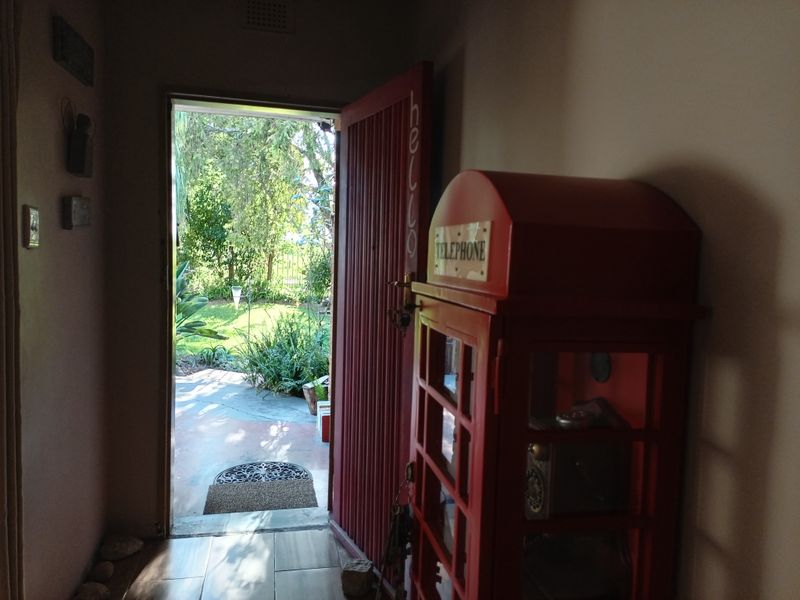 Entrance hallway featuring tiled flooring and a solid timber door opening out to a garden area.