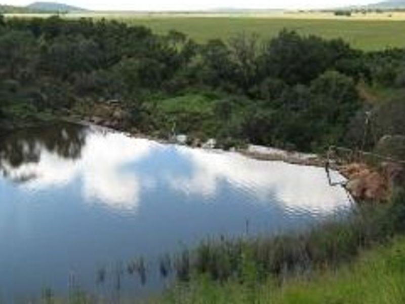 A scenic view of a natural dam and surrounding landscape on the vacant residential property.
