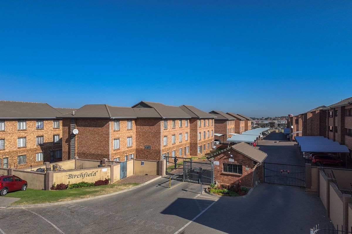 Aerial view of the Birchfield apartment complex featuring face brick buildings, secure gated access, and covered parking bays.