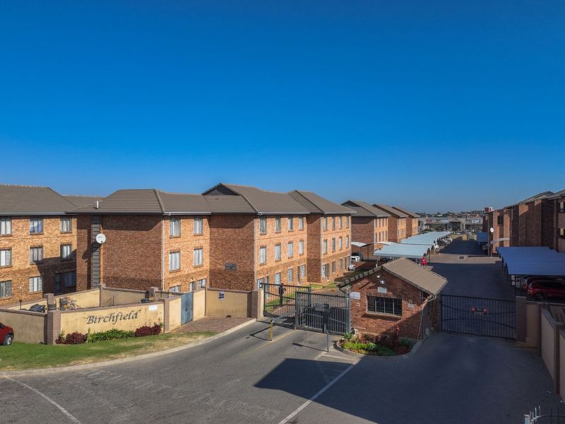 Aerial view of the Birchfield apartment complex featuring face brick buildings, secure gated access, and covered parking bays.
