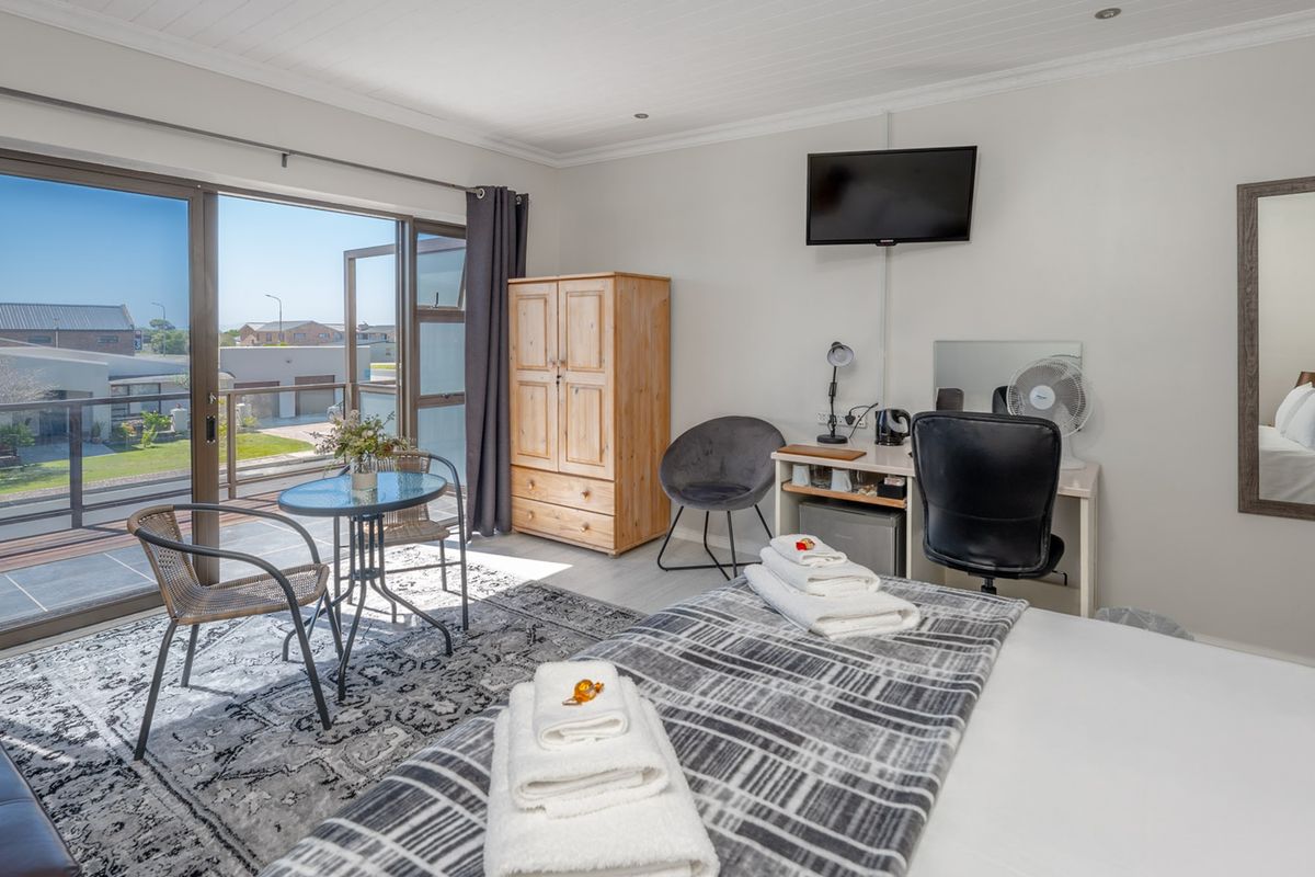 Spacious bedroom featuring large sliding glass doors that open onto a private balcony, providing ample natural light and outdoor access.