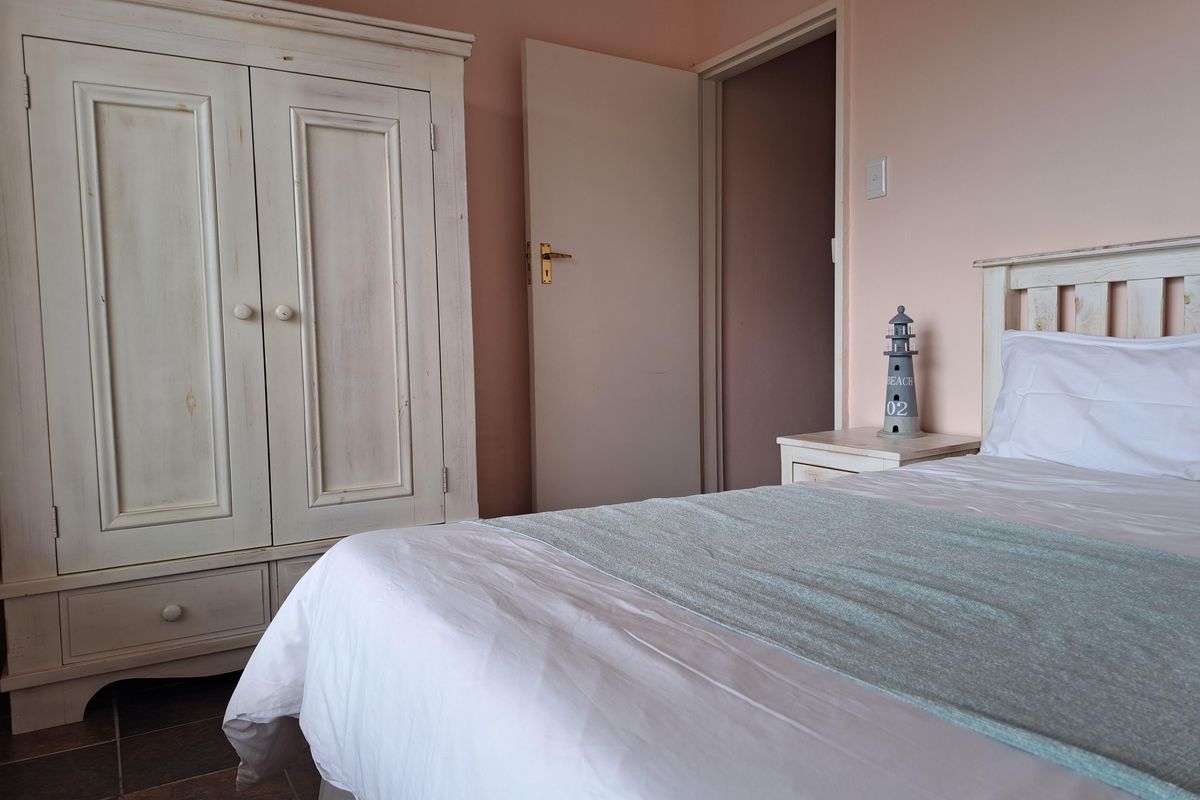 A bedroom featuring tiled flooring and a neutral wall finish, providing a functional and comfortable sleeping space.