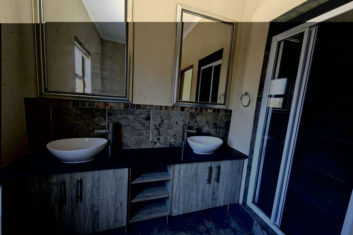 A modern bathroom featuring a double vanity with vessel sinks, stone-look splashback, and a separate shower enclosure.