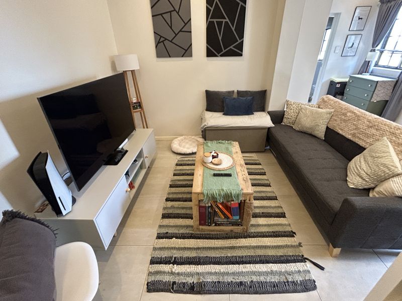 A comfortable living room featuring neutral tiled flooring and a clean, modern layout suitable for relaxation.