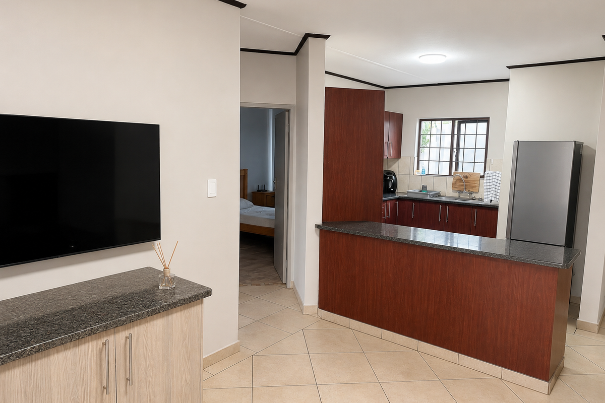 Open plan living area featuring a kitchen with dark wood cabinetry, granite countertops, breakfast bar, and tiled flooring throughout.
