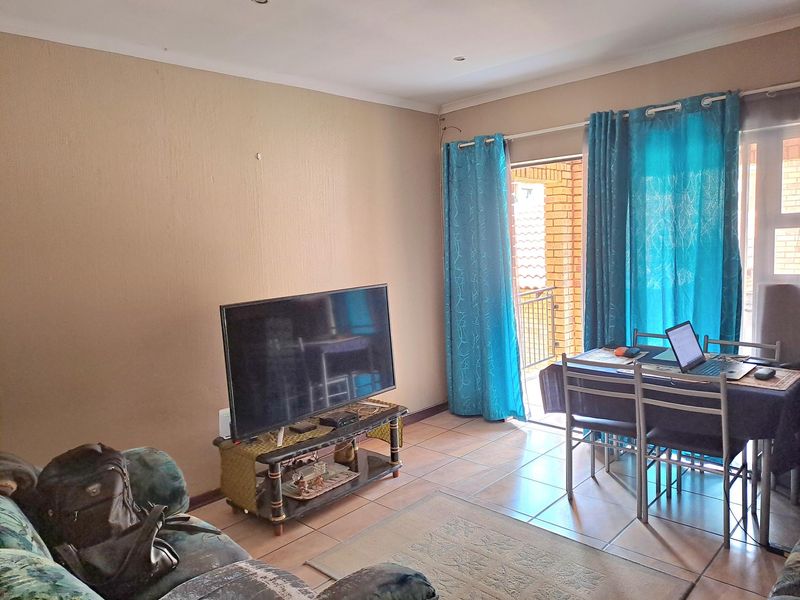 Open plan living and dining area featuring tiled flooring and direct access to a private balcony through sliding glass doors.