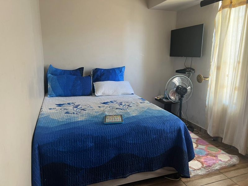 A compact bedroom featuring tiled flooring and neutral wall finishes, suitable for a single bed setup.