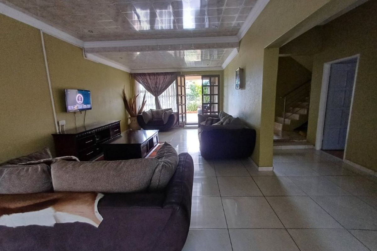 Spacious living room featuring ceramic floor tiles, a unique tiled ceiling, and direct access to an outdoor patio area.