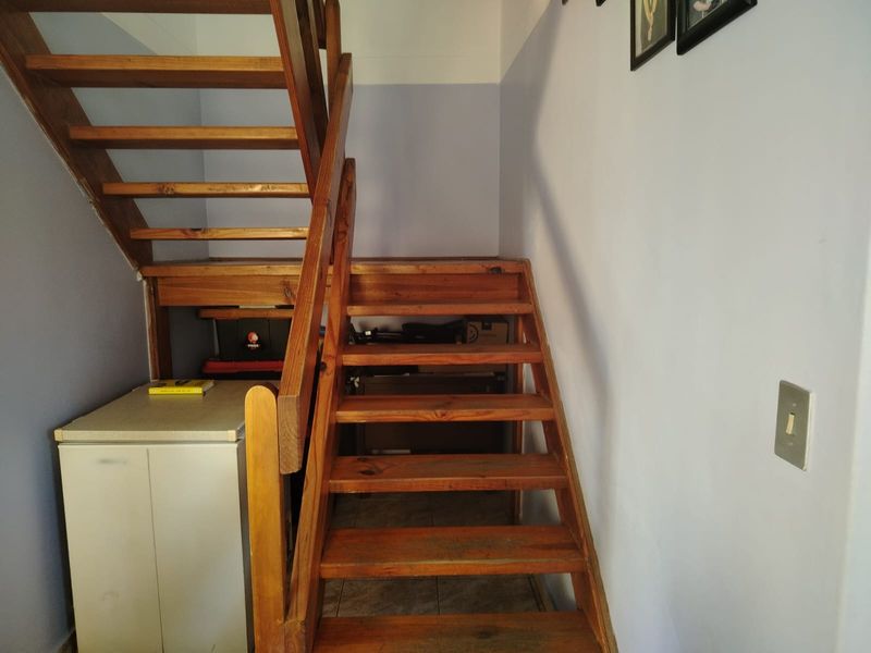 A functional timber staircase providing access to the upper level, featuring an open-tread design and simple wooden balustrade.