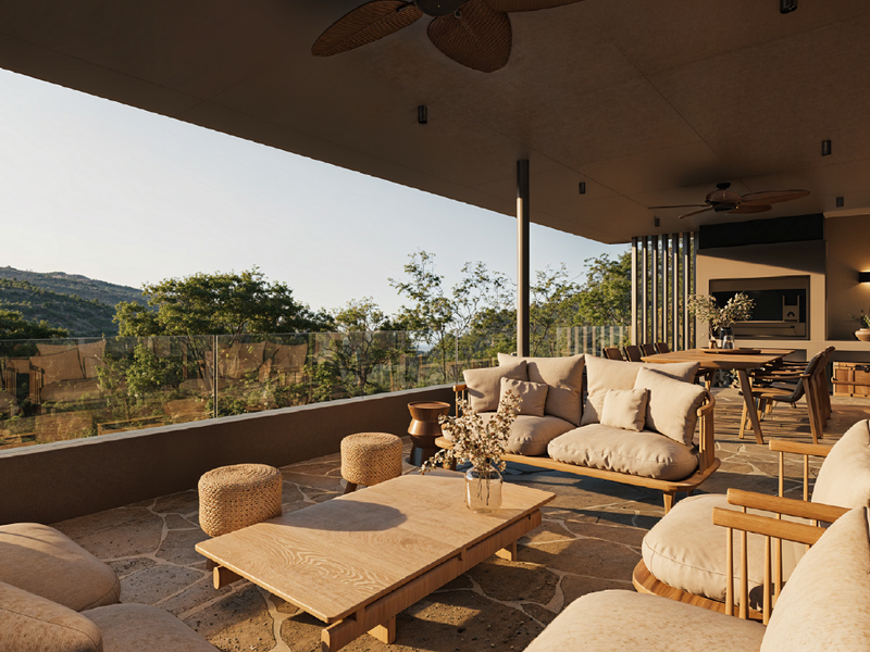 Spacious covered patio featuring stone flooring, a glass balustrade, built-in fireplace, and scenic elevated views of the surrounding landscape.